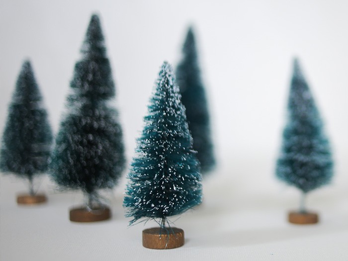 Collection of miniature faux pine trees with snow-tipped branches.